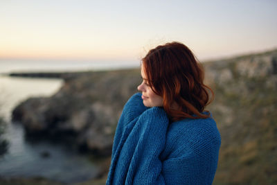 Woman standing on beach against sky during sunset