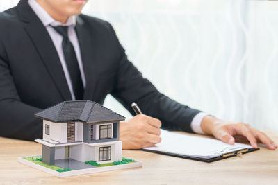 Midsection of man holding camera on table