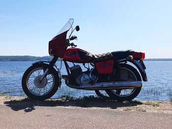 Bicycle by sea against clear sky