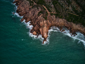 High angle view of sea waves splashing on rocks