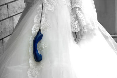 Midsection of bride with blue telephone receiver