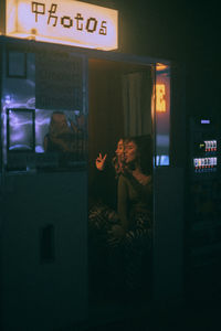 Young multiracial friends enjoying together while photographing in photo booth at nightclub