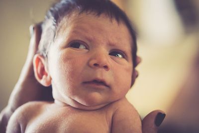 Cropped hands of mother carrying son at home