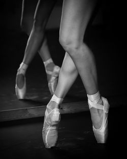 Low section of man dancing against black background