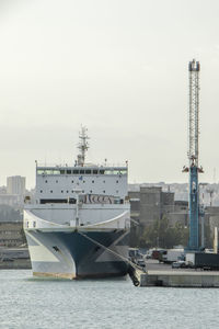 Ship moored at harbor against sky