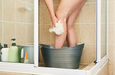 Low section of woman standing in bathroom