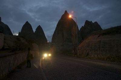 Rear view of woman on road at sunset