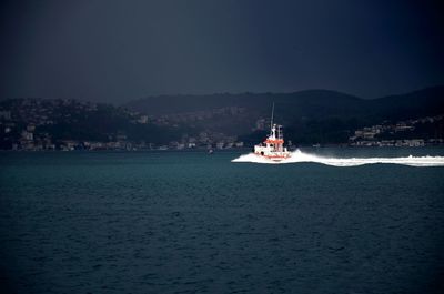 Sailboat sailing on sea against sky at night