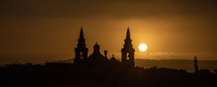 Silhouette of temple building against sky during sunset