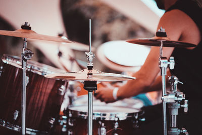 Midsection of man playing drum outdoors