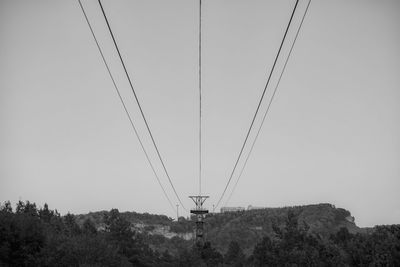 Low angle view of overhead cable car against sky