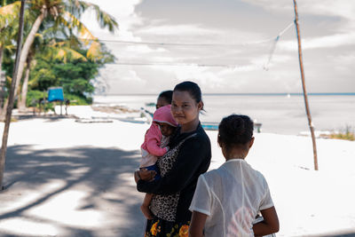 Rear view of mother with daughter against sky