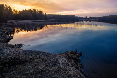 Scenic view of lake against sky at sunset