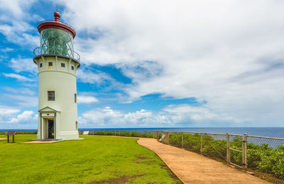 Lighthouse by sea against sky