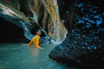 Full length of man standing on rock in cave