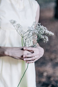 Midsection of bride holding flowers