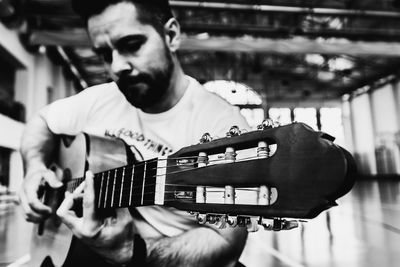 Close-up of man playing acoustic guitar