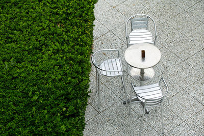 Metal coffee table near a hedge