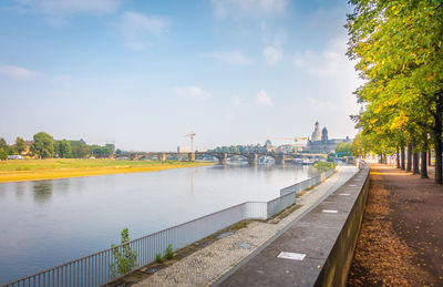 Bridge over river in city against sky