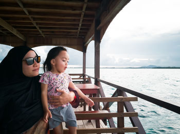 Mother with daughter looking at sea from boat