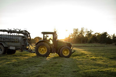 Tractor on field at sunset