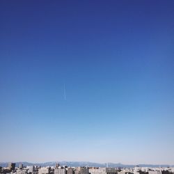 View of cityscape against clear blue sky