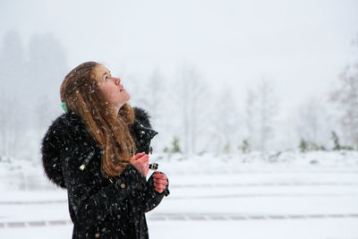 Young woman standing on snow covered landscape