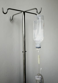 Close-up of iv drip hanging against wall in hospital