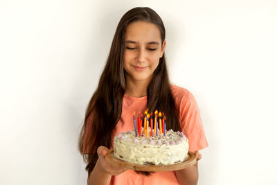 Portrait of teenage girl holding ice cream against white background