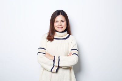 Portrait of a smiling young woman against white background