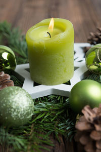 Close-up of lit candle on wreath