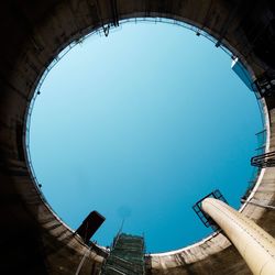 Directly below shot of buildings against blue sky
