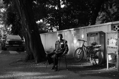 Man sitting on cart against trees