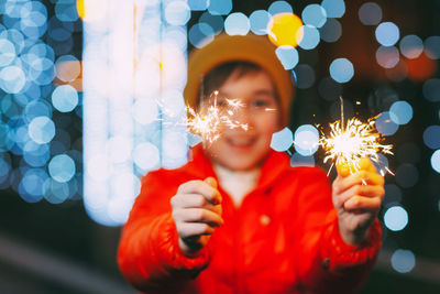 Close-up of sparklers in the hands of a boy celebrating new year or christmas 