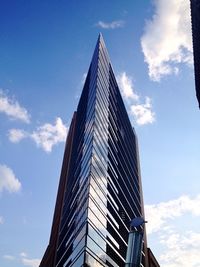 Low angle view of modern building against cloudy sky