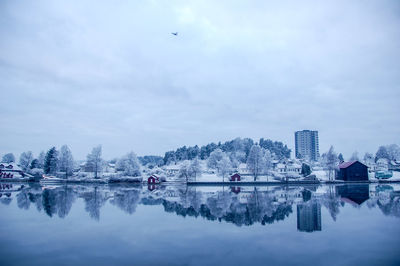 Scenic view of lake by buildings against sky