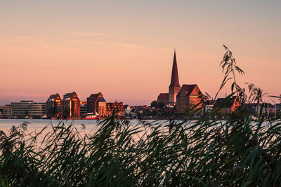 Panoramic view of river and buildings against sky during sunset