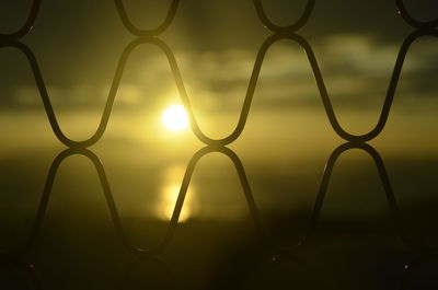 Close-up of silhouette metal against sky during sunset