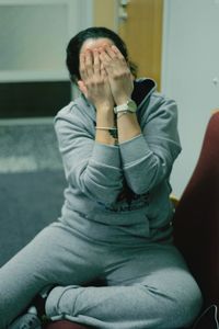 Full length of woman covering face with hands