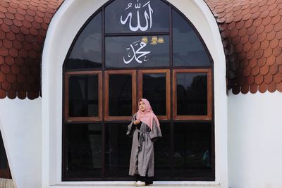 Woman standing against building