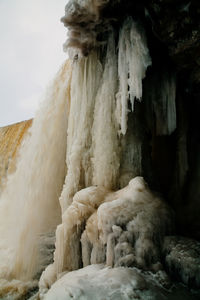 Close-up of snow on rock against sky