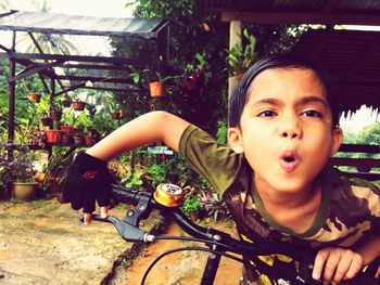 Portrait of boy with bicycle on flower