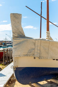 Sailboats moored at shore against sky