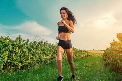 Woman running across the field. short black shorts and top. sunny day. person