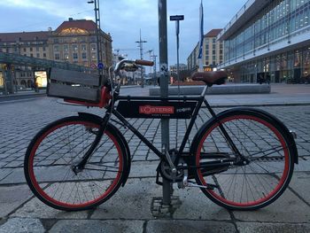 Bicycle parked on street against buildings