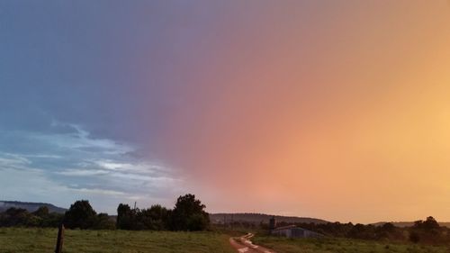 View of field against sky during sunset