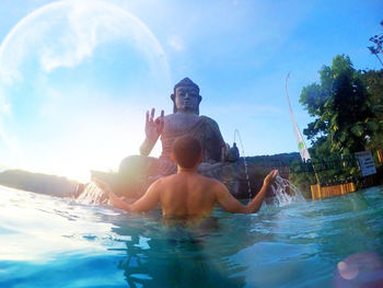 People enjoying in swimming pool against sky