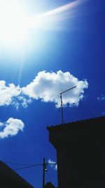 Low angle view of electricity pylon against cloudy sky