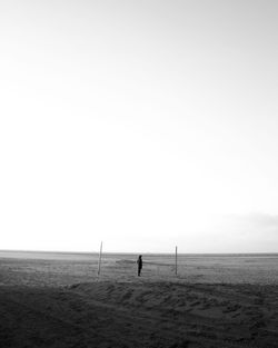 Man standing on beach against clear sky