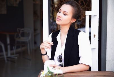 Young woman holding ice cream in restaurant